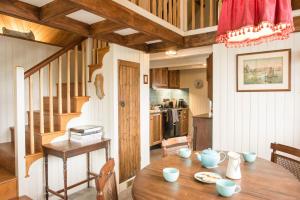 a dining room with a table and a kitchen at The Boathouse at Old Court in Strangford