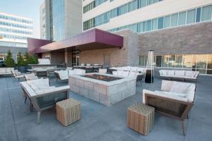 un patio avec un foyer extérieur et des chaises ainsi qu'un bâtiment dans l'établissement Residence Inn by Marriott Cincinnati Midtown/Rookwood, à Cincinnati