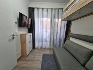 ein kleines Wohnzimmer mit einem Sofa und einem Fenster in der Unterkunft FeWo Am Meer Prora in Binz