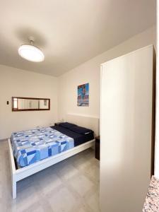 a bedroom with a bed with blue and white sheets at Aeolian Apartments in Lipari
