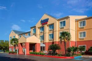 a hotel with palm trees in front of a building at Fairfield Inn & Suites Lafayette I-10 in Lafayette