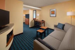 una sala de estar con sofá y escritorio en una habitación de hotel en Fairfield Inn & Suites Lafayette I-10, en Lafayette