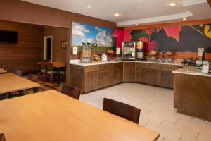 a restaurant with wooden tables and a food counter at Fairfield Inn & Suites Lafayette I-10 in Lafayette