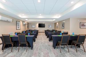 einen Konferenzraum mit Tischen, Stühlen und einem Bildschirm in der Unterkunft Courtyard by Marriott Amarillo Downtown in Amarillo