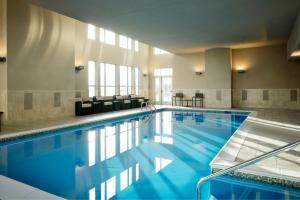 a large swimming pool with blue water in a building at Residence Inn by Marriott Grand Rapids Airport in Grand Rapids