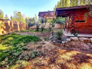 un patio trasero de una casa con un edificio en Cabaña de Montaña en Luján de Cuyo