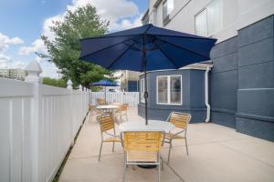 een tafel en stoelen met een parasol op een patio bij Fairfield Inn and Suites by Marriott Nashville Smyrna in Smyrna