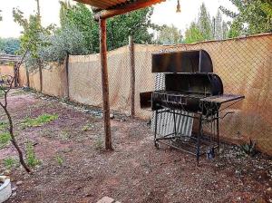 una parrilla sentada en un patio junto a una valla en Cabaña de Montaña en Luján de Cuyo