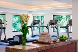 a fitness room with a treadmill and a vase of flowers at Goa Marriott Resort & Spa in Panaji