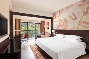 a hotel room with a bed and a television at Goa Marriott Resort & Spa in Panaji