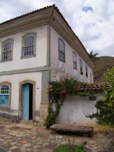 an old house with a bench in front of it at Casa de João in Ouro Preto
