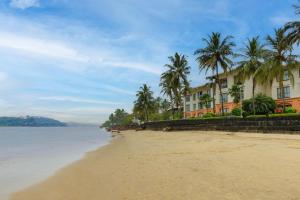a hotel on the beach with palm trees and the ocean at Goa Marriott Resort & Spa in Panaji