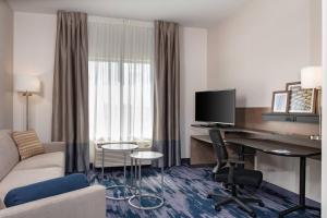una camera d'albergo con divano e scrivania con computer di Fairfield Inn & Suites Charlotte Pineville a Charlotte