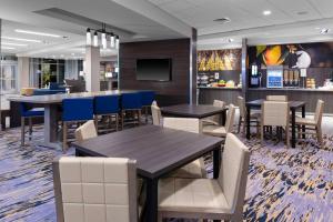 a restaurant with tables and chairs and a bar at Fairfield Inn & Suites Charlotte Pineville in Charlotte