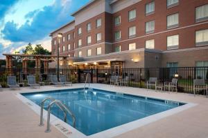a hotel swimming pool in front of a building at Fairfield Inn & Suites Charlotte Pineville in Charlotte