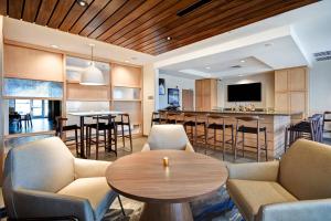 sala de estar con mesas y sillas y cocina en Fairfield Inn & Suites by Marriott Plymouth en Plymouth