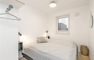 レンブルッフにあるCozy Apartment In Lembruchdümmer Seeのベッドと窓のある白い寝室