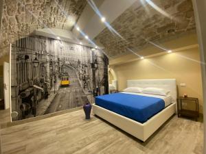 Un dormitorio con una cama azul y una pintura en la pared en Solo Vip, en Trani