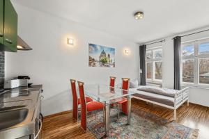 a kitchen and dining room with a glass table and chairs at Budget Apartment am Fernsehturm in Berlin