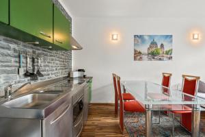 a kitchen with a sink and a table with chairs at Budget Apartment am Fernsehturm in Berlin