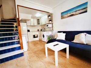 sala de estar con sofá azul y mesa en Bonita casa al lado de la playa en Santa Pola, en Santa Pola