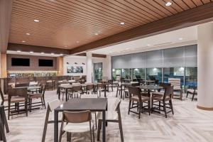 a restaurant with tables and chairs and a bar at Fairfield Inn & Suites Houston Memorial City Area in Houston