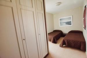 Dormitorio pequeño con 2 camas y armario en near the port, wide, confortable, WI-FI, terrace, aircon en Morro del Jable
