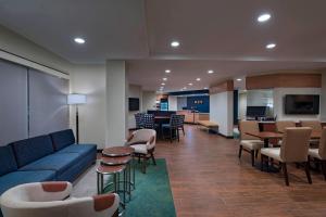 een lobby met een blauwe bank, stoelen en tafels bij TownePlace Suites by Marriott Tacoma Lakewood in Lakewood