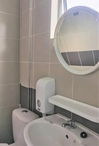 ein Badezimmer mit Toilette, Waschbecken und Spiegel in der Unterkunft Emerald Avenue Cozy 3R3B Apartment - 329 in Brinchang + 16 Fotos