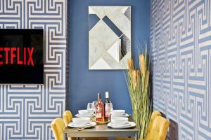 jadalnia ze stołem i niebieską ścianą w obiekcie Platinum Grove Modern Flat w mieście Kent