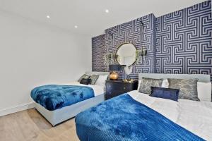 a bedroom with two beds and a mirror at Platinum Grove Modern Flat in Kent