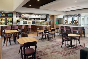 a restaurant with tables and chairs and a bar at Courtyard by Marriott Raleigh Cary in Cary