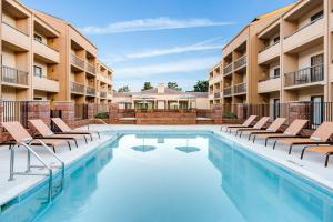 una piscina con tumbonas y un complejo en Courtyard by Marriott Raleigh Cary, en Cary