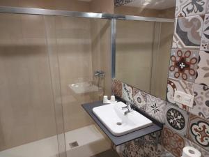 a bathroom with a sink and a glass shower at Hotel - Hostel Atuvera in Santo Domingo de la Calzada