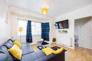 uma sala de estar com um sofá de couro azul em 3 BR House w Parking Close to Shops em Goodmayes