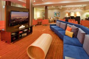 a waiting room with blue couches and a flat screen tv at Courtyard by Marriott Pittsburgh North/Cranberry Woods in Cranberry Township