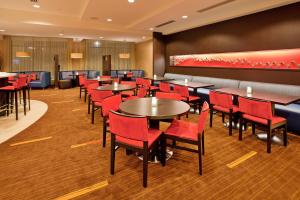 a dining room with tables and red chairs at Courtyard by Marriott Pittsburgh North/Cranberry Woods in Cranberry Township