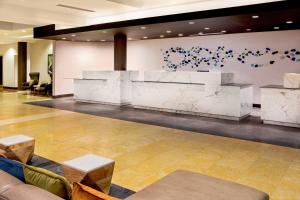 a lobby with a white marble counter and tables at Delta Hotels by Marriott Chesapeake Norfolk in Chesapeake