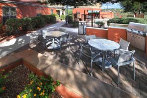 eine Terrasse mit einem Tisch und Stühlen sowie einem Tisch und Stühlen in der Unterkunft TownePlace Suites Tucson in Tucson