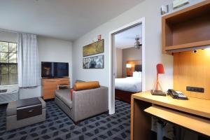 a hotel room with a bed and a chair and a desk at TownePlace Suites Tucson in Tucson
