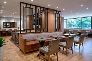 a restaurant with tables and chairs and windows at Houston Marriott Westchase in Houston