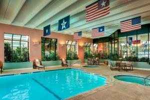 an indoor pool with american flags in a hotel at Houston Marriott Westchase in Houston