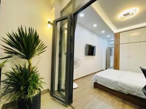 Thai Van Home في مدينة هوشي منه: غرفة نوم مع سرير وزرع الفخار