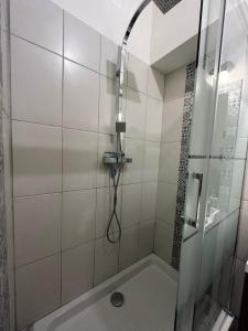 a shower with a glass door and a tub at Entre Loire et Chateau in Blois