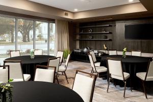 a conference room with two tables and chairs and a tv at Courtyard by Marriott Dallas Downtown/Reunion District in Dallas