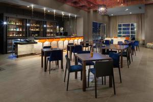 a restaurant with tables and chairs and a bar at Courtyard by Marriott Dallas Downtown/Reunion District in Dallas