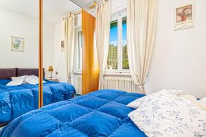 a bedroom with two blue beds and a window at Lerici 5 Terre casa il Bivio 1989 in Lerici