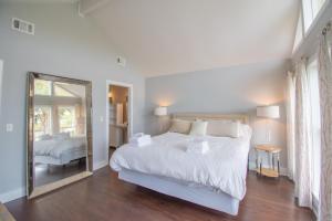 Fripp Island的住宿－3 Fairway Club Dr，白色卧室设有一张大床和镜子