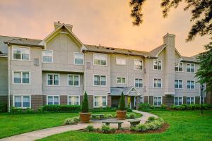 a large building with a park in front of it at Residence Inn Atlanta Norcross/Peachtree Corners in Norcross