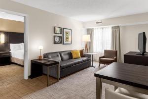 a hotel room with a couch and a bed at Residence Inn Atlanta Norcross/Peachtree Corners in Norcross